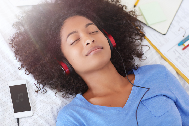 Woman laying down and listening to audio